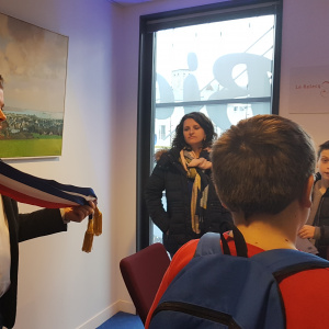 M. Péron présentant l'écharpe de maire aux élèves